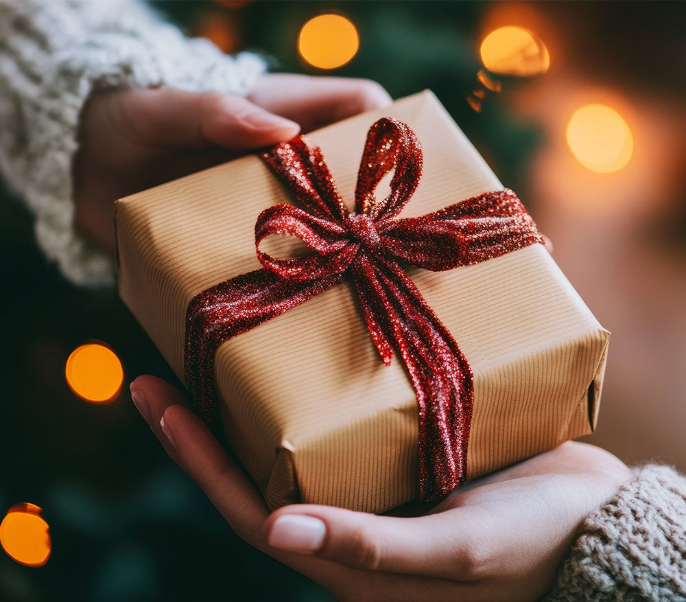 Ein liebevoll verpacktes Weihnachtsgeschenk wird übergeben