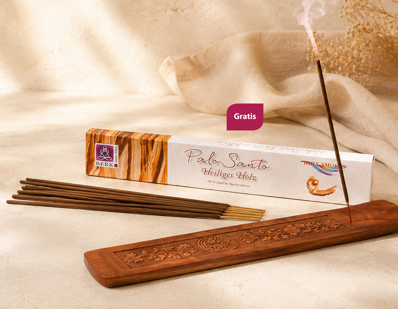 Palo-Santo-Räucherstäbchen mit Verpackung, geschnitztem Holzhalter und glimmendem Räucherstäbchen in einem hellen, warmen Arrangement mit sanftem Sonnenlicht, Leinentuch und dezenter Trockenblumen-Deko.