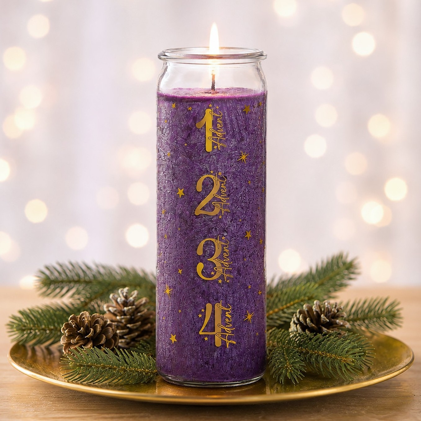 Eine brennende violette Adventskerze mit goldenen Zahlen von 1 bis 4 steht auf einem goldenen Teller, umgeben von Tannenzweigen und Zapfen.