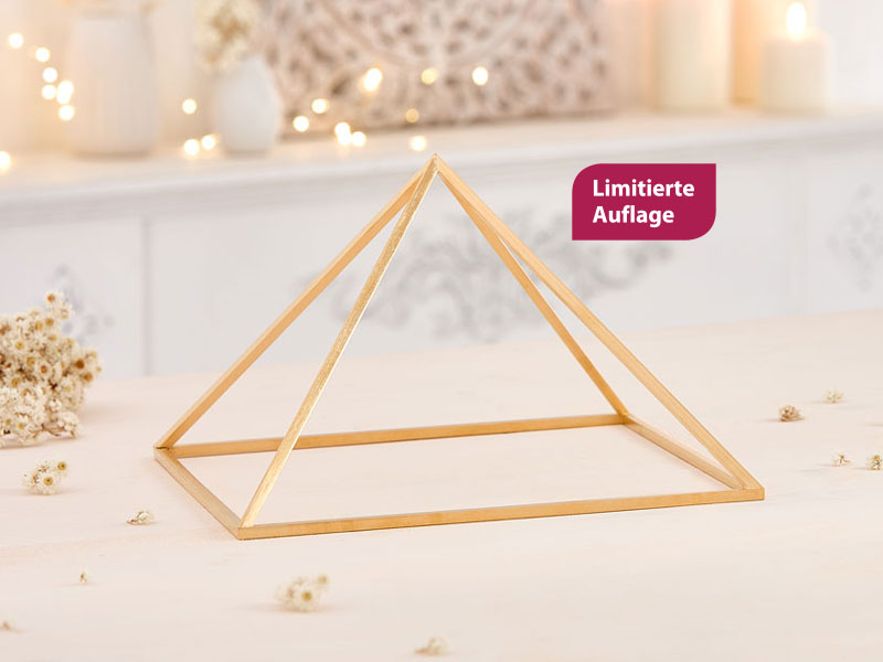 Eine filigrane Pyramide aus vergoldetem Metall steht auf einem hellen Holztisch. Ein Label weißt das Produkt als limitiert aus.